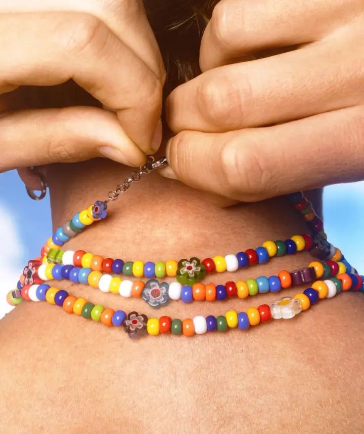 Dettaglio collana dell'amicizia Twin Things al collo, perline colorate e fiori millefiori in vetro di Murano